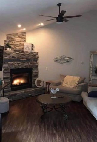 Fireplace area with seating, and a TV, and a space where one can sleep